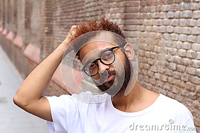 Handsome ethnic male touching his curly hair Stock Photo
