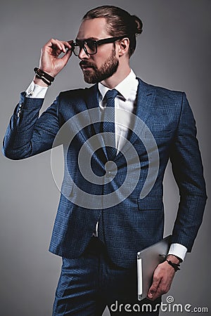 Handsome fashion businessman dressed in elegant blue suit on gray background Stock Photo