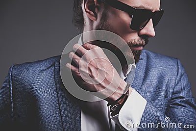 Handsome fashion businessman dressed in elegant blue suit on gray background Stock Photo