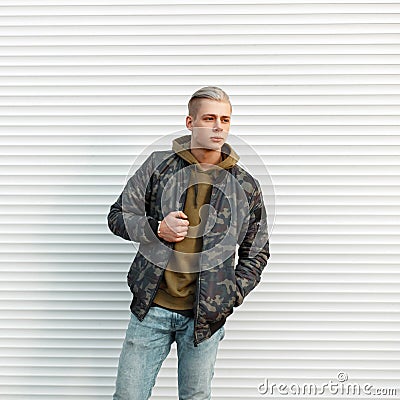 Handsome fashionable man in trendy military jacket with hoodie Stock Photo