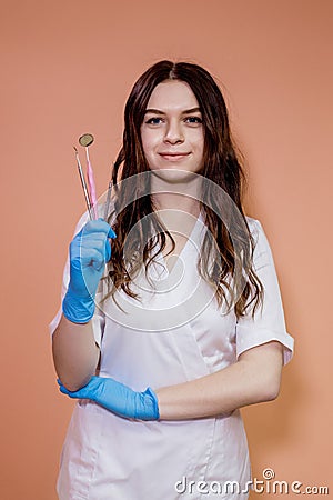 Handsome gloved dentist holding professional tools for dental treatment Stock Photo