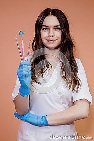 Handsome gloved dentist holding professional tools for dental treatment Stock Photo