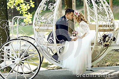 Handsome groom kissing blonde beautiful bride in magical fairy t Stock Photo