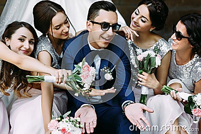 Handsome groom surrounded by beautiful bridesmaids Stock Photo