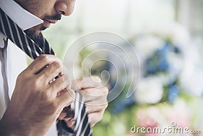 Handsome groomsman wear tie preparing to be best man for groom in a wedding day. Formal suit. Wedding concept Stock Photo