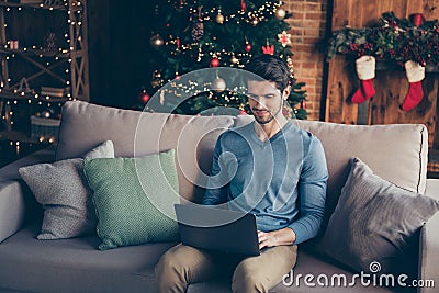 Handsome guy sit couch use computer search christmas season sales to buy fairy magic presents having house with Stock Photo