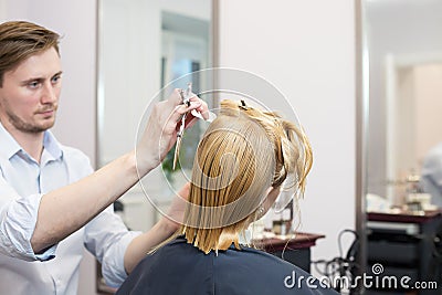 Handsome hairdresser making highlighting coloring Stock Photo