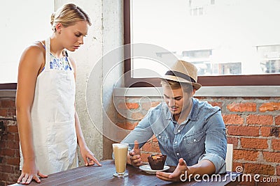 Handsome hipster complaining to blonde waitress Stock Photo