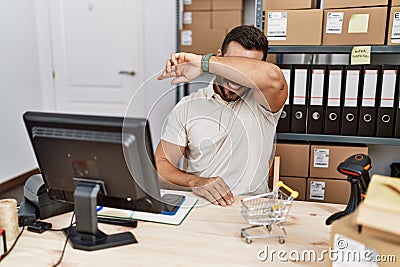 Handsome hispanic man working at small business commerce smiling cheerful playing peek a boo with hands showing face Stock Photo