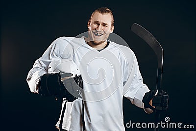 Handsome hockey player. Smiling at camera isolated on black background. Stock Photo