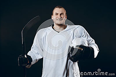 Handsome hockey player. Smiling at camera isolated on black background. Stock Photo