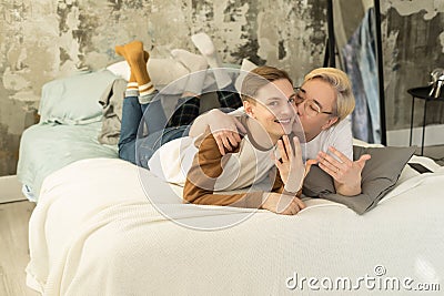 Handsome international homosexual couple who recently married relaxing in bed before night sleep and looking at camera Stock Photo