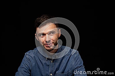 Handsome laughing man in denim shirt looking away Stock Photo