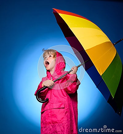 Handsome little guy in preparing for Autumn. Cheerful boy in raincoat with colorful umbrella. Kid in rain. Cloud rain Stock Photo