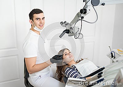 Handsome male dentist with happy female patient in modern dental clinic. Dentistry. Stomatology equipment Stock Photo