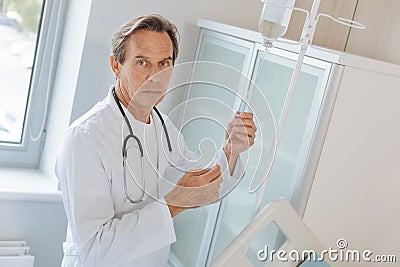 Handsome male doctor setting up the IV Stock Photo