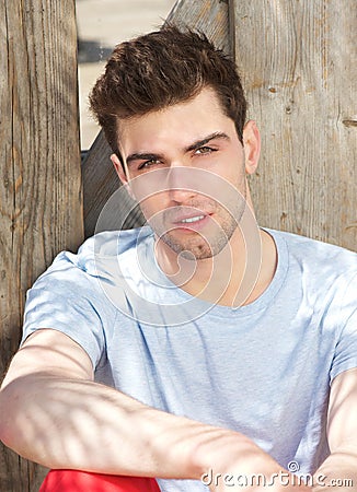 Handsome male fashion model sitting outdoors Stock Photo