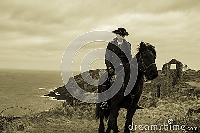 Handsome Male Horse Rider Regency 18th Century Poldark Costume with tin mine ruins and Atlantic ocean in background Stock Photo