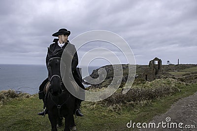 Handsome Male Horse Rider Regency 18th Century Poldark Costume with tin mine ruins and Atlantic ocean in background Stock Photo