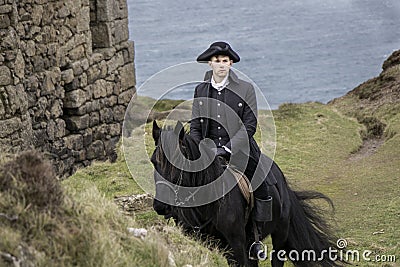 Handsome Male Horse Rider Regency 18th Century Poldark Costume with tin mine ruins and Atlantic ocean in background Stock Photo