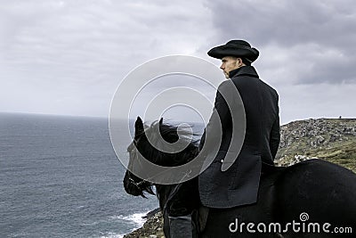 Handsome Male Horse Rider Regency 18th Century Poldark Costume with tin mine ruins and Atlantic ocean in background Stock Photo