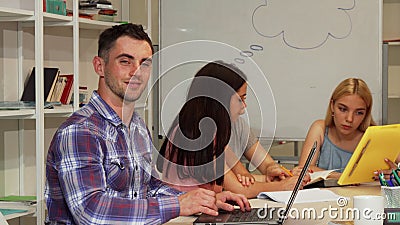 Handsome male student showing thumbs up while using laptop Stock Photo