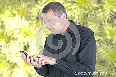 Handsome man in black shirt outdoor texting in cell smartphone Stock Photo