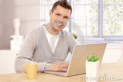 Handsome man browsing internet at home smiling Stock Photo