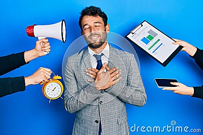 Handsome man business with beard working at the office being stressed out smiling with hands on chest, eyes closed with grateful Stock Photo