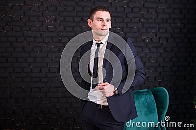 Handsome man in a business suit against a black brick wall, model photo. Succesful fashionable man Stock Photo