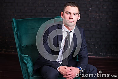 Handsome man in a business suit against a black brick wall, model photo. Succesful fashionable man Stock Photo