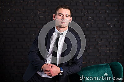 Handsome man in a business suit against a black brick wall, model photo. Succesful fashionable man Stock Photo