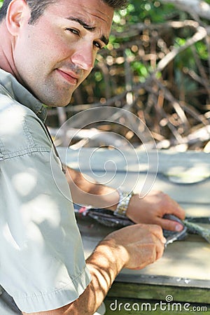 Handsome man filleting a fish vertical Stock Photo