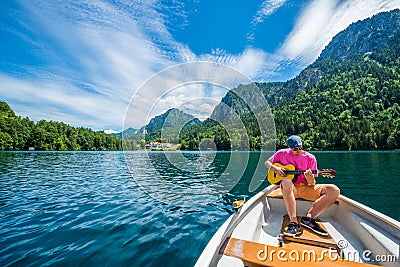 A handsome man is is having a genuine beautiful moment on a little boat in the lake Stock Photo