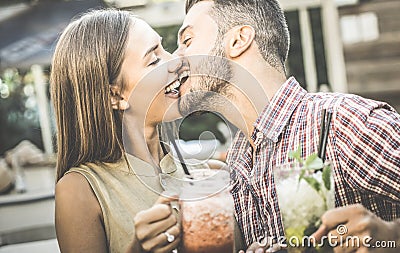 Handsome man kissing young woman at fashion cocktail bar Stock Photo