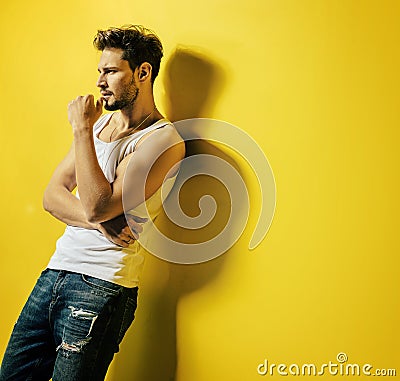 Handsome man leaning on the bright, yellow wall Stock Photo