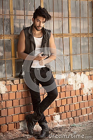 Handsome man model dressed punk, hipster posing dramatic in grun Stock Photo
