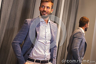 Young man in new suit front checkroom Stock Photo