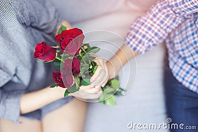 Handsome man plaid shirt hand holding out Bouquet of beautiful with red rose flower. Stock Photo