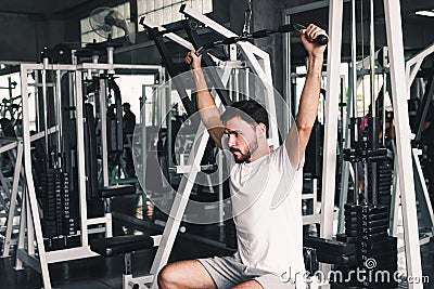 Handsome Man is Rowing Exercise With Bodybuilder Equipment in Fitness Club.,Portrait of Strong Man doing Working Out Calories Stock Photo