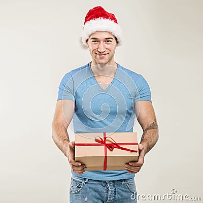 Handsome man in santa hat - hand gift box Stock Photo