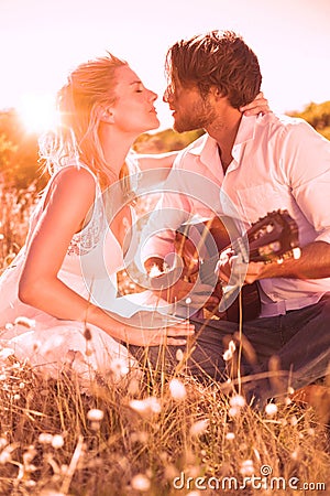 Handsome man serenading his girlfriend with guitar Stock Photo