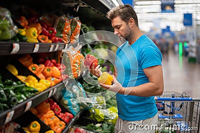 Handsome man with shopping basket with grocery. Man buying groceries in supermarket. Male model in shop. Concept of Stock Photo