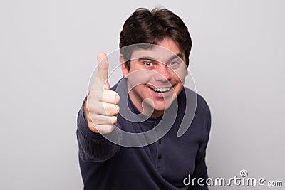 Handsome man showing thumbs up sign. Smiling positive man Stock Photo