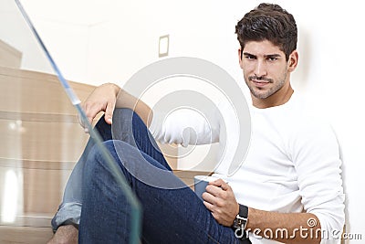 Handsome man sitting on stairs with coffee Stock Photo