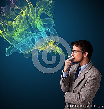 Handsome man smoking cigarette with colorful smoke Stock Photo