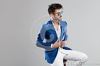 Handsome man with sunglasses buttons suit and looks to side Stock Photo