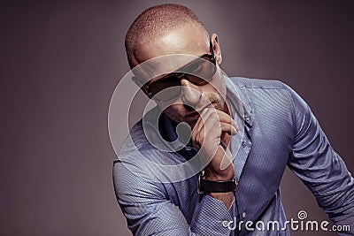 Handsome man in sunglasses sitting thinking Stock Photo