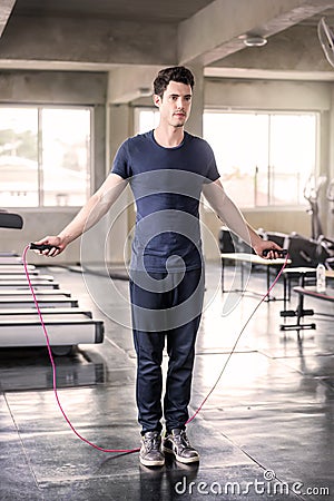 Handsome man training with his skipping rope best cardio workout at fitness gym Stock Photo