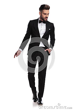 Handsome man in tuxedo is snapping fingers and looks away Stock Photo